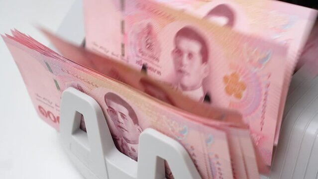 Slow Motion Shot of Thai Baht money counting in Machine. Paper THB Thai baht banknotes. Fast cash note count in Machine Counting. Business and economy in Thailand concept.