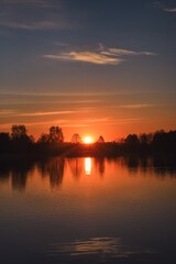 Wonderful morning landscape in Poland. The sun over the lake in a colorful sky.