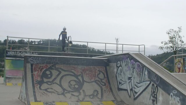 young boy jumping ramps at skatepark