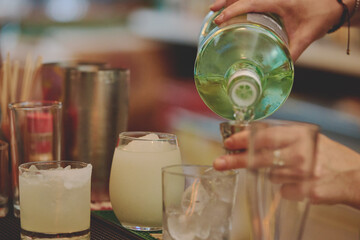 Female barman preparing drinks. cocktail bar Drinks at the bar. Fresh and cold drinks in a bar. Watermelon drink, jamiaca drink, margarita, micheladas.
