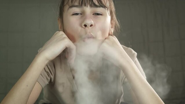 Enjoy steam by humidifier. A teen enjot the white steam from the clean ionizier humidifier in the room.