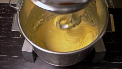 Mixing a dough for bread baking with professional kneader spiral machine at the manufacturing. The dough is kneaded for burgers. Very luscious lush air bun.