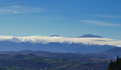 Fototapeta premium Montagne innevate e vallate nel cielo azzurro in una tersa giornata di sole invernale