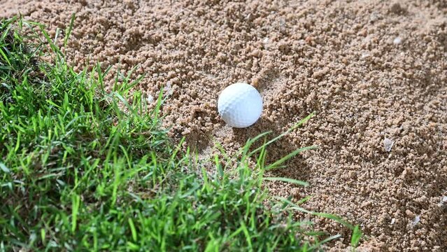 golf ball rolling dow in sand banger