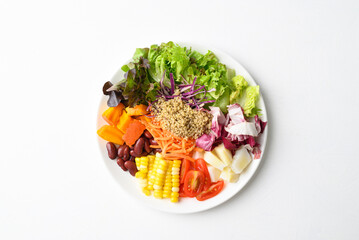 Mixed fresh salad organic vegetables with quinoa seeds on white background, Healthy vegan food, Table top view