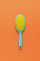 A bright yellow-blue comb on a bright orange background.