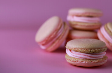 macaroons with pink buttercream on a purple background with copy space