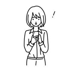 立ってスマートフォンを操作して何かに気づいて驚いたブラウスの女性