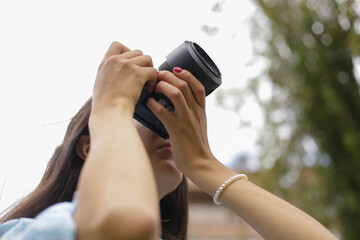 Fotógrafa revisando su cámara con cielo despejado