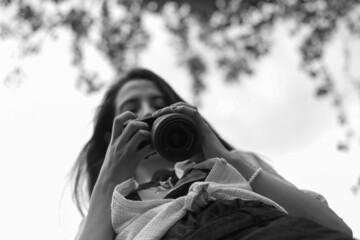 Fotógrafa revisando su cámara con cielo despejado