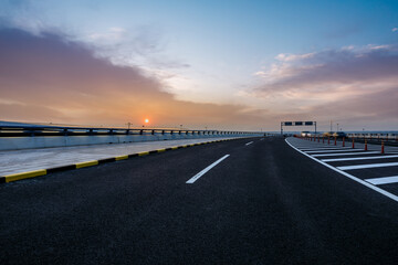 Fototapeta premium Asphalt highway and sky sunset clouds background