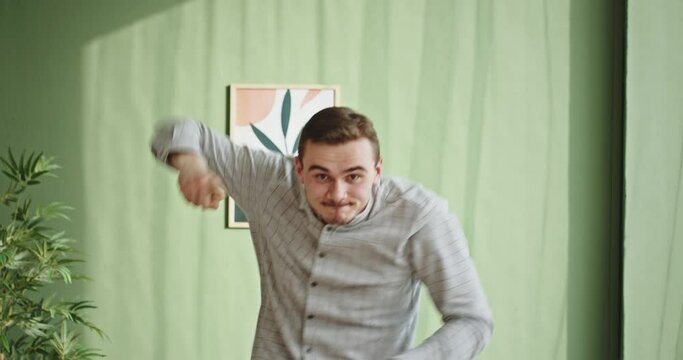 Ecstatic excited male winner dancing in office hallway laughing celebrating work achievement professional win, happy overjoyed business man enjoy victory dance euphoric about success reward promotion