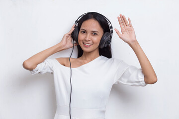 Beautiful young asian woman listening to music isolated on white background
