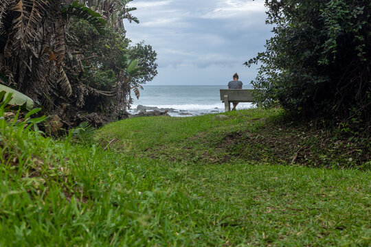 woman alone on a beanch with ocean and moody sky