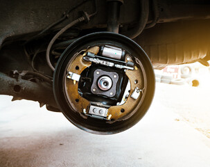 Component inside the automotive brake drum without a wheel on hydraulic car lift in the auto repair...