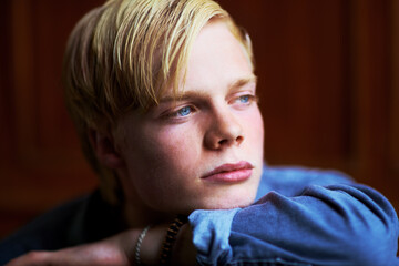 Wondering what the future holds. Thoughtful and handsome young blonde guy with very blue eyes.