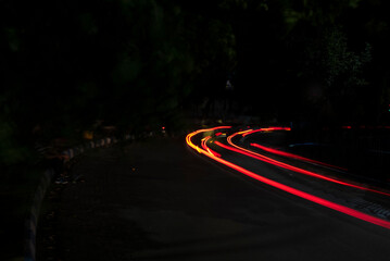 Car Light trails on a city street in a dark black night. Photo is taken with long exposure.