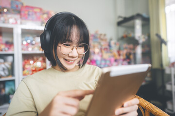 Young adult asian woman wear headphone listen music and relax using smartphone for relax at home