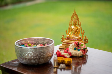 Flower garlands, water bowls, perfume and white clay filler for Buddha bathing ceremony on...