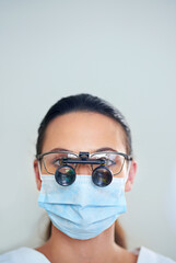 Lets take a closer look. Portrait of a young female dentist wearing magnifying glasses.