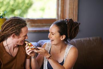 Theres nothing as tasty as pizza. Shot of a Rastafarian couple eating pizza.