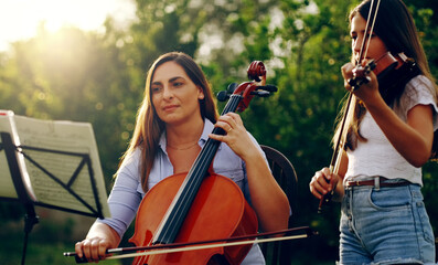 She taught her daughter how to play. Cropped shot of a mother and daughter playing musical instruments together in the backyard.