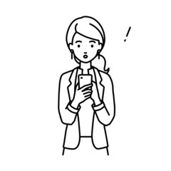 立ってスマートフォンを操作して何かに気づいて驚いたジャケットの女性