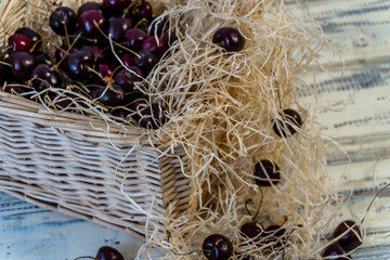 Cherry and cherry juice or wine on a wooden table, a decanter and a glass with juice, a basket with...