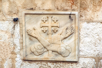 Old Christian emblem incorporated in old walls inside Old City of Jerusalem, Israel.