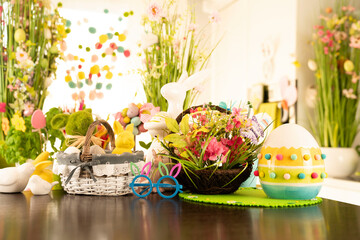 Easter time. Easter decorations on the shining wooden table. Easter bunny, easter eggs in basket and cabbage leaf.