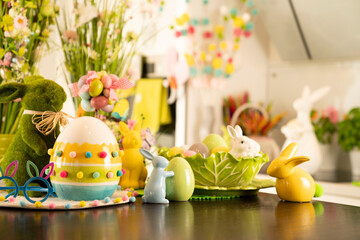 Easter time. Easter decorations on the shining wooden table. Easter bunny, easter eggs in basket and cabbage leaf.