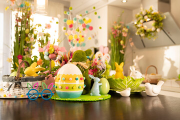 Easter time. Easter decorations on the shining wooden table. Easter bunny, easter eggs in basket...