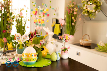 Easter time. Easter decorations on the shining wooden table. Easter bunny, easter eggs in basket and cabbage leaf.