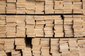 Wooden boards folded in bundles closeup. Textures of wooden building materials.