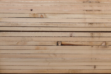 Wooden boards folded in bundles closeup. Textures of wooden building materials.