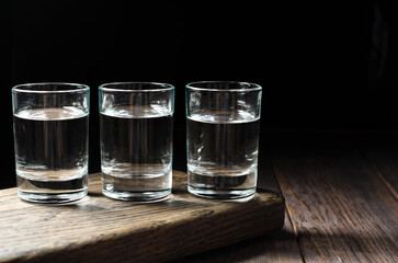 Glasses with Russian vodka on a brown wooden background. Copy space