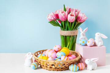ink tulips, easter bunnies with colorful eggs in basket and blue background.