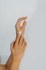 cropped shot of a woman applying moisturizer to her hands. Well-groomed female hands on a white background. cold season protection of the skin of the hands.