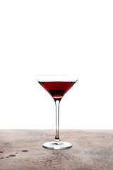 A splash in a coupe glass with a red color cocktail, shot with back light
