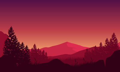 The beautiful view of mountains with trees silhouette from the countryside at sunset