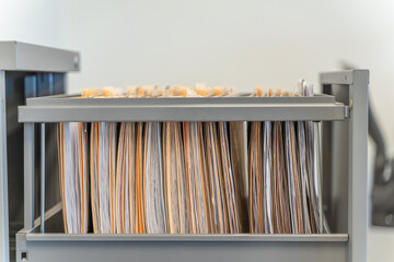 Hanging files in filling cabinet in an office at work - obrazy, fototapety, plakaty