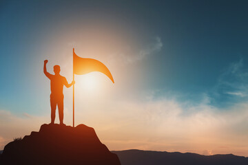 Business Success, Leadership and Success and Goal Concepts. Silhouette of businessman with flags on mountain peaks above sky and sunset background.