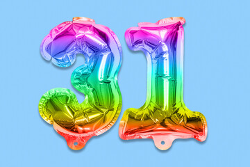 Rainbow foil balloon number, digit thirty one on a blue background. Birthday greeting card with inscription 31. Top view. Numerical digit. Celebration event, template.