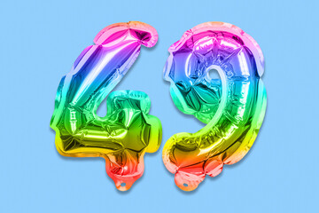 Rainbow foil balloon number, digit forty nine on a blue background. Birthday greeting card with inscription 49. Top view. Numerical digit. Celebration event, template.
