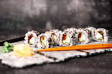 A photo of sushi that you can use for menus and advertisements. Sushi and rolls on a dark background.