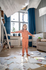 A girl among the mess and scattered sheets in the room.