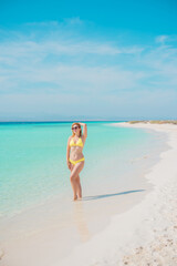 Ukrainian woman in yellow swimsuit in vacation, behind blue landscape, fashionable details