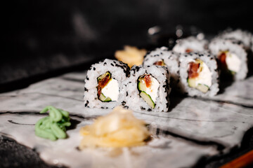 A photo of sushi that you can use for menus and advertisements. Sushi and rolls on a dark background.