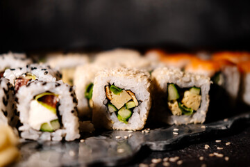 A photo of sushi that you can use for menus and advertisements. Sushi and rolls on a dark background.