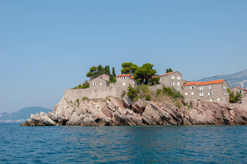 mountain island in the sea with old houses and pine trees
